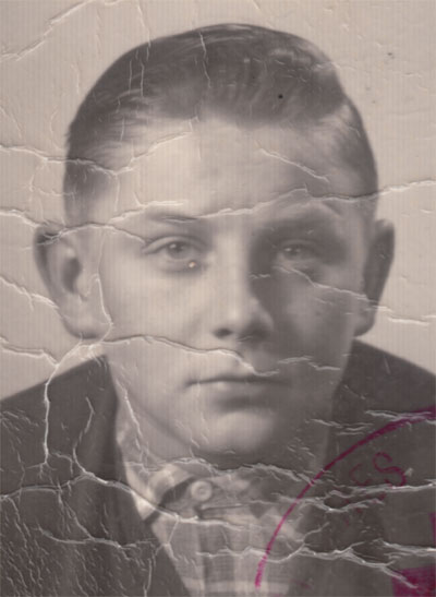 Vorher-Foto eines Jungen aus den 50er Jahren mit Rissen und Stempel